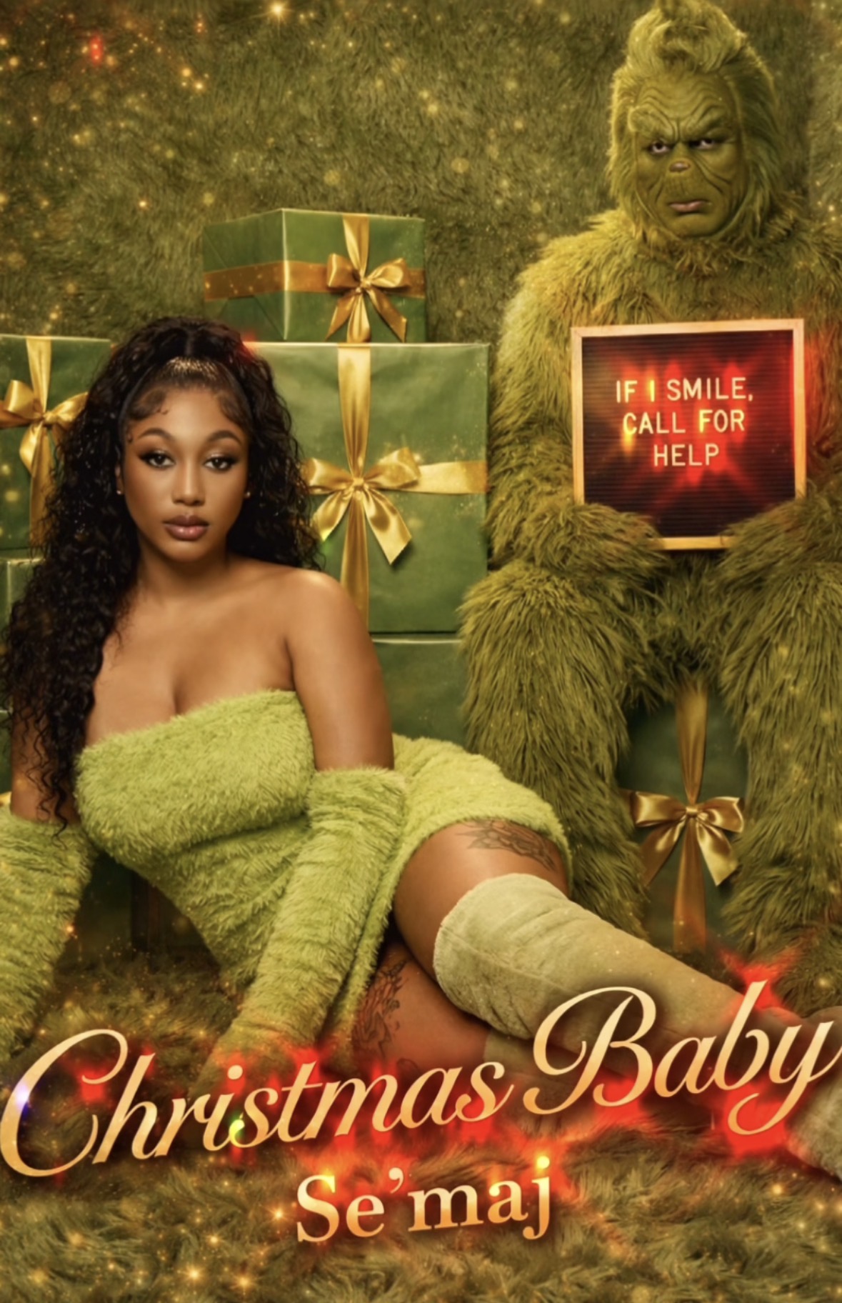 A woman in a green outfit and a person in a green furry costume sit among Christmas presents, holding a sign.