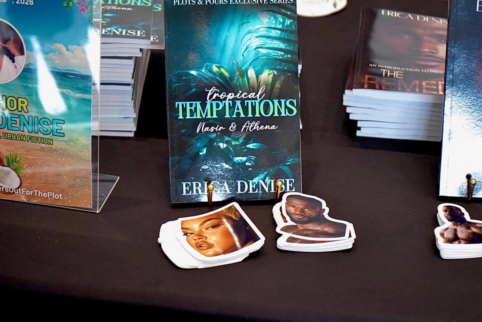 Book titled 'Tropical Temptations' displayed on table with character cutouts around it.