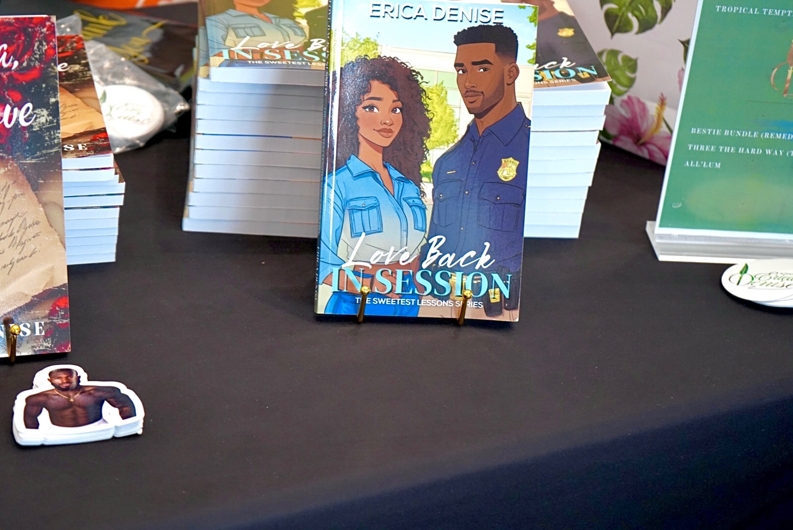 Book titled 'Back in Session' featuring a woman and man on the cover, displayed on a table with other books.