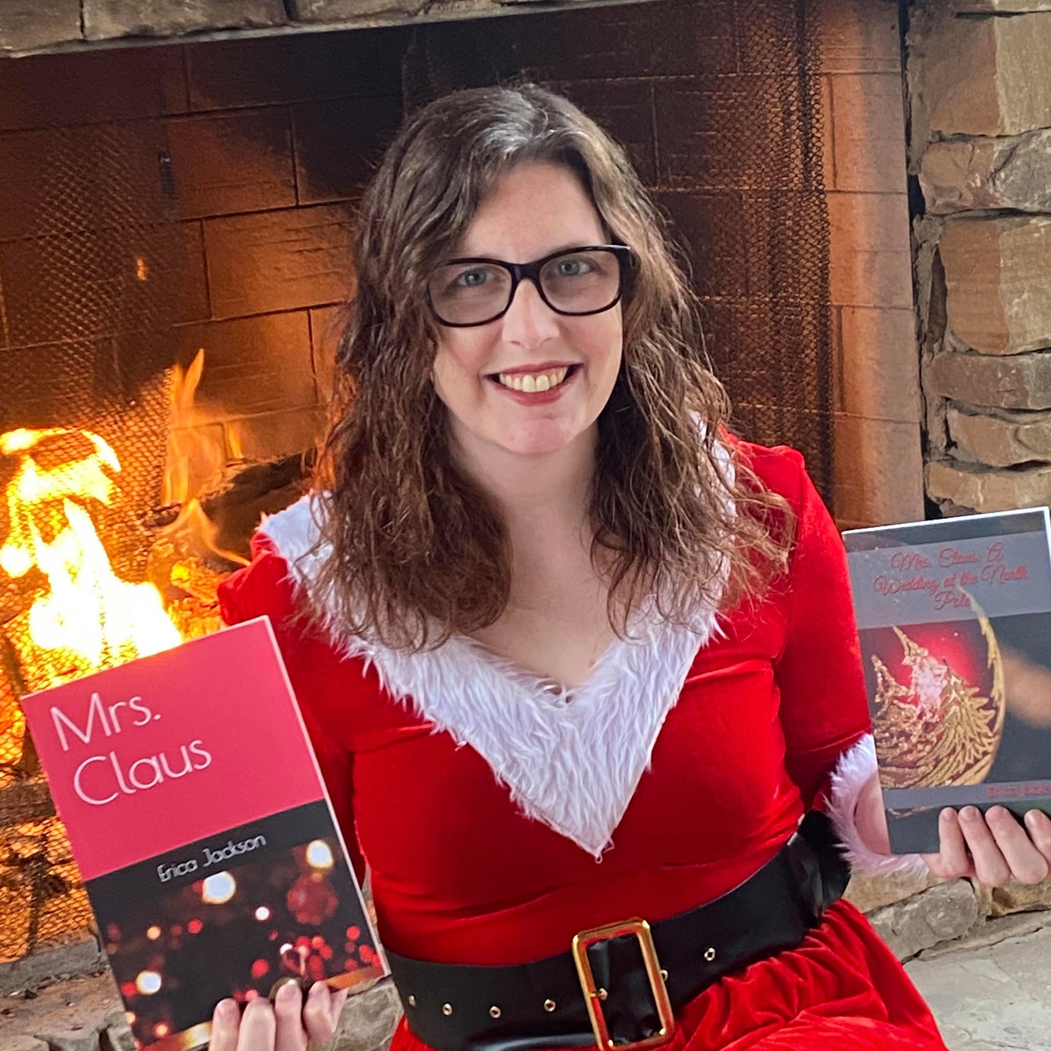 Woman dressed as Mrs. Claus in front of a fireplace, holding a book titled 'Mrs. Claus'.