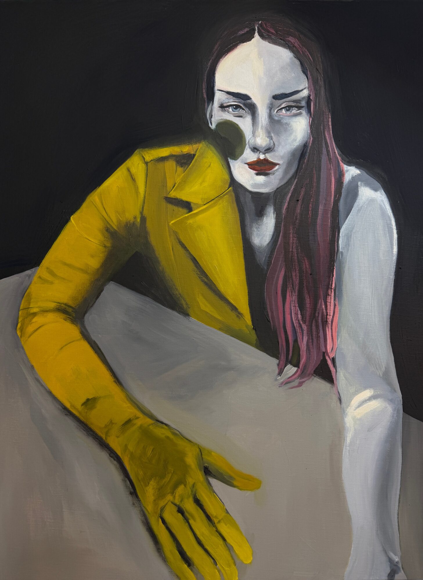 Portrait of a woman with long hair, wearing a yellow jacket, resting her arm on a surface, with a dark background.