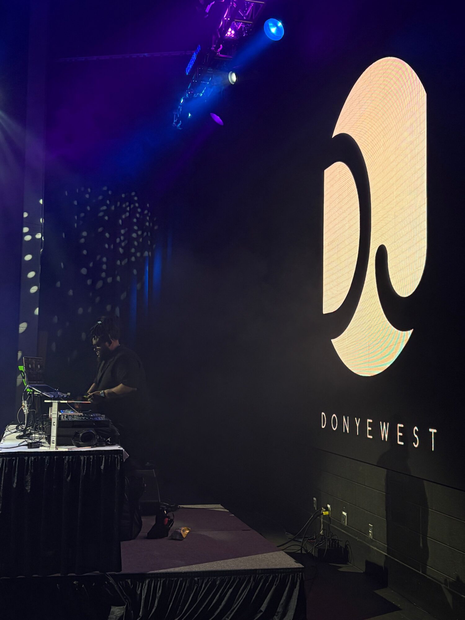 Large illuminated logo with the word 'DOWNEAST' on a dark background, part of an indoor event or display.