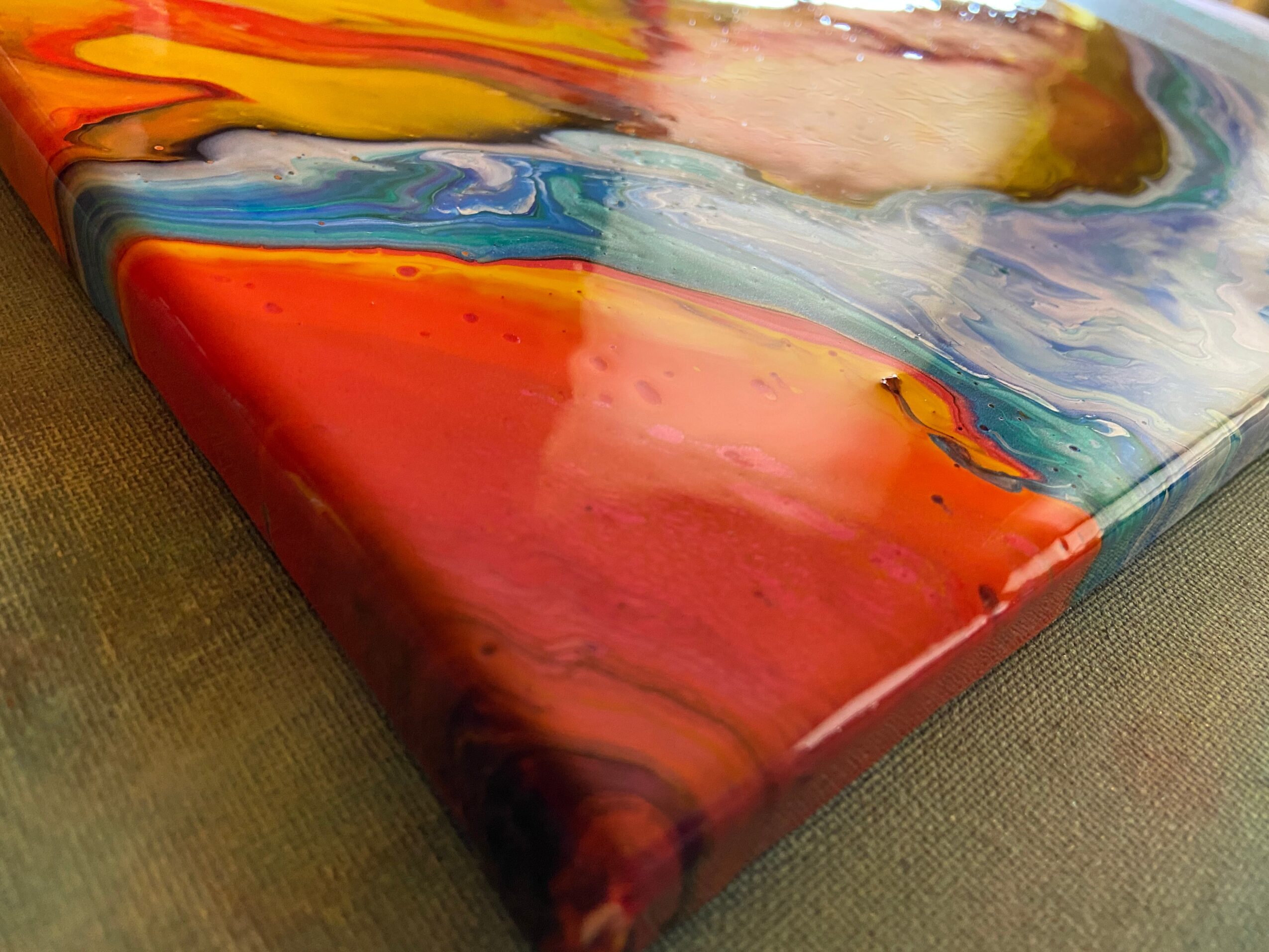 Close-up of a colorful abstract painting with swirling patterns and vibrant colors on a canvas.