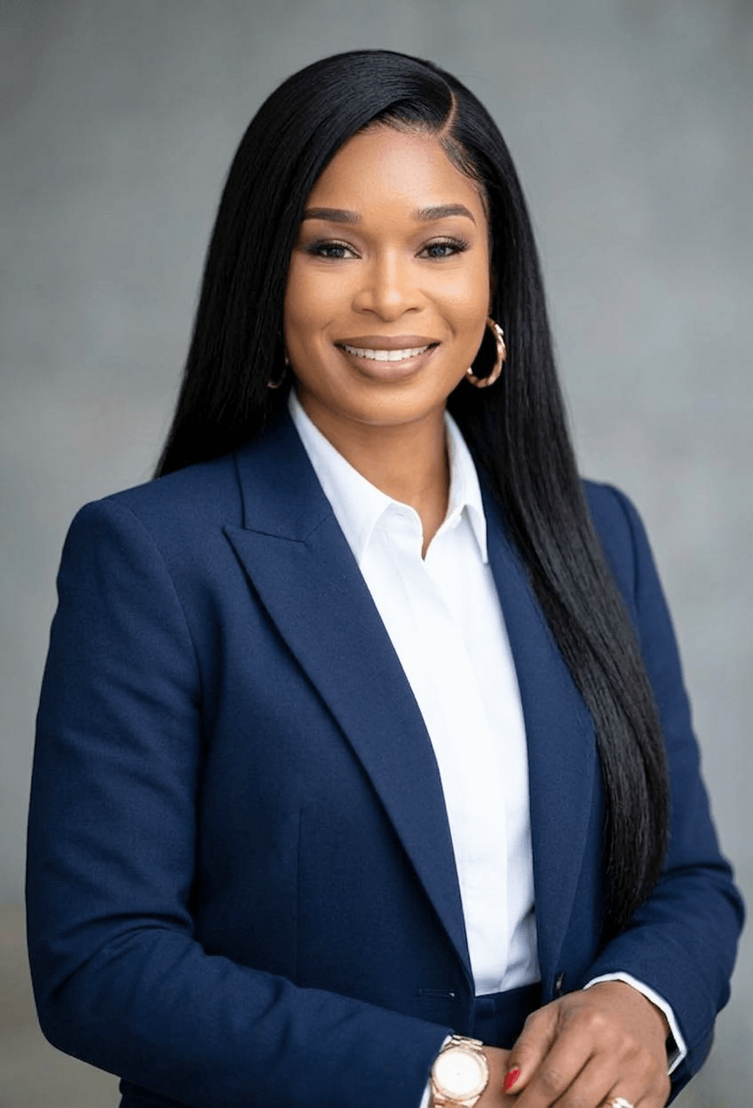 Professional woman with long black hair, wearing a navy blazer, white shirt, and gold hoop earrings, smiling confidently.