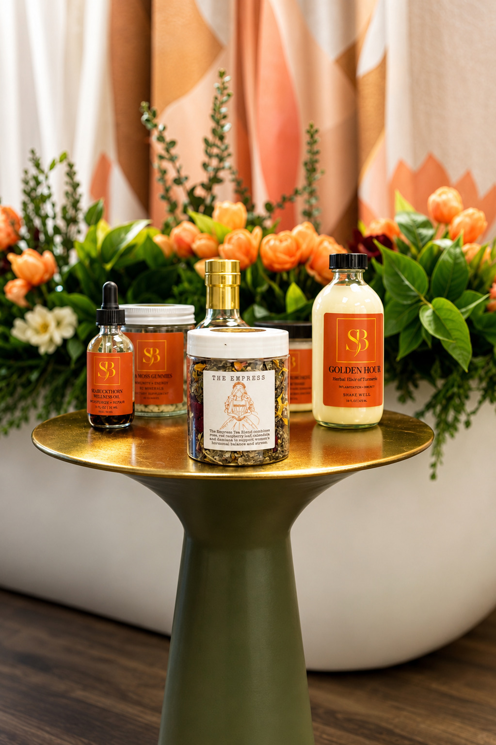 Three bottles of skincare products on a round table with a floral arrangement in the background.